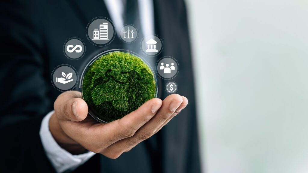 man holding a green earth-like sphere with business icons surrounding it